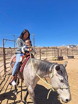 LaShai Jake riding a horse with her child