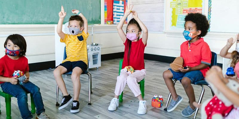 a group of young children in class wearing masks