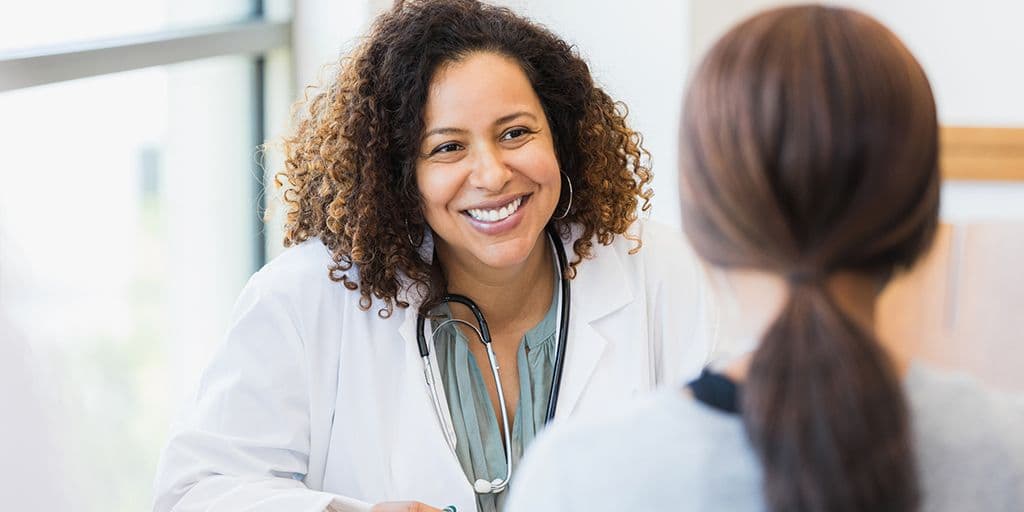 a smiling healthcare provider talks to a patient