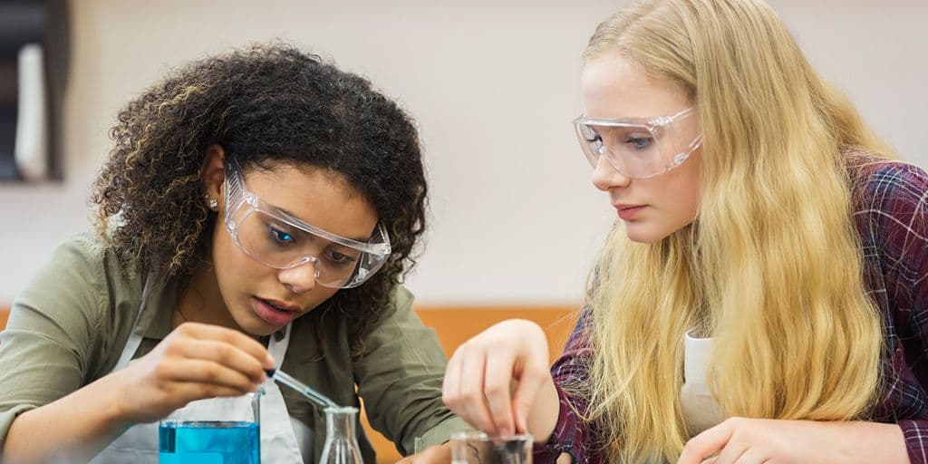 two girls work in science class