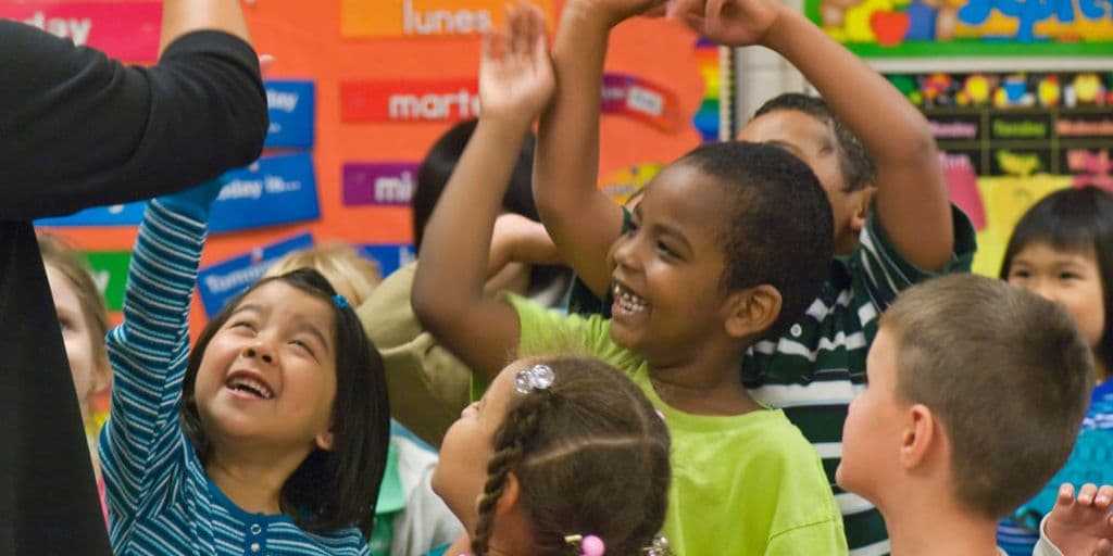 young children high five their teacher