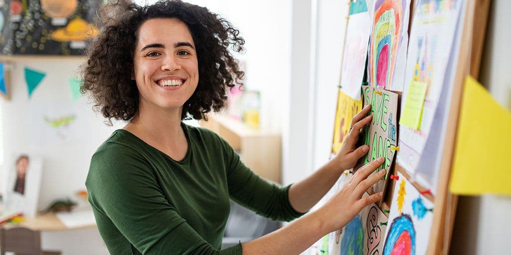 a teacher smiles in their classroom