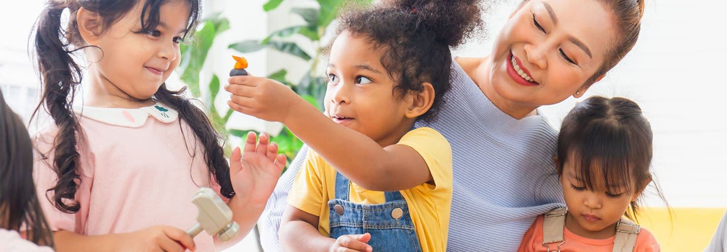 young children play at daycare with their teacher
