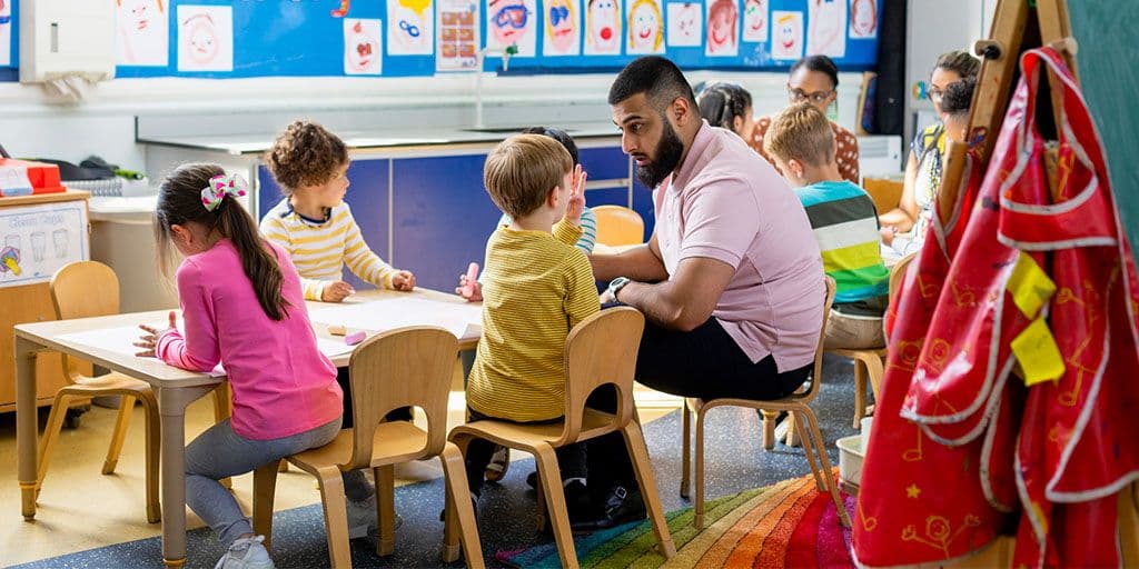 a teacher talks to children at daycare