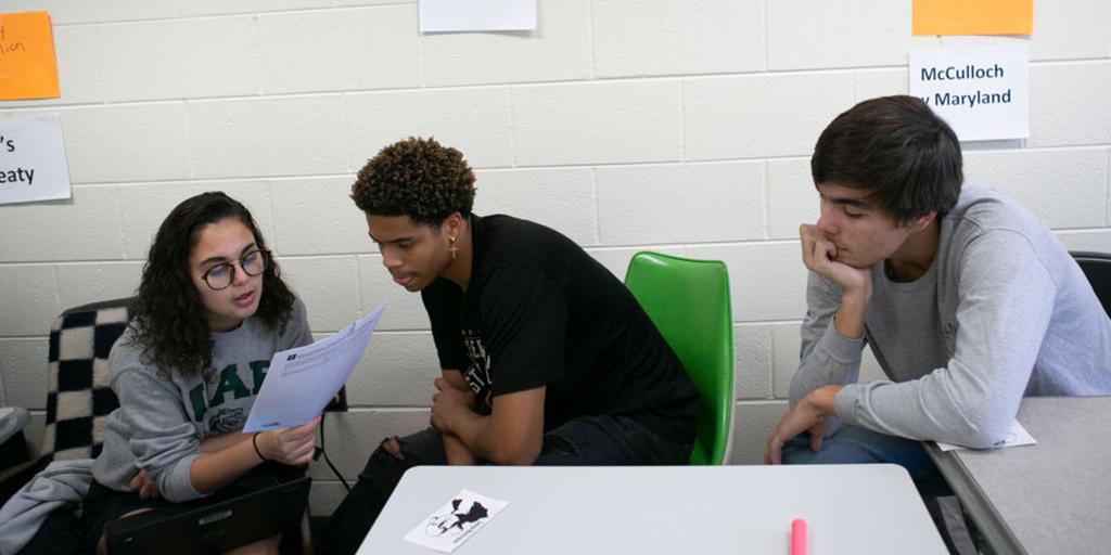 Three students sit in class together