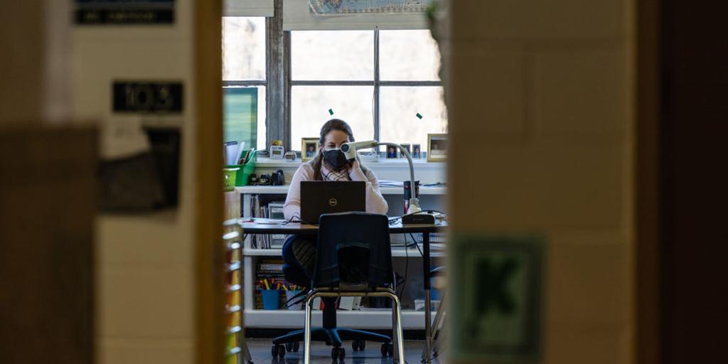 a teacher sits at her desk during school