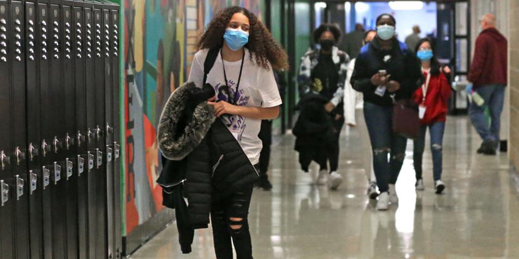 a teenaged student walks down the school hallway