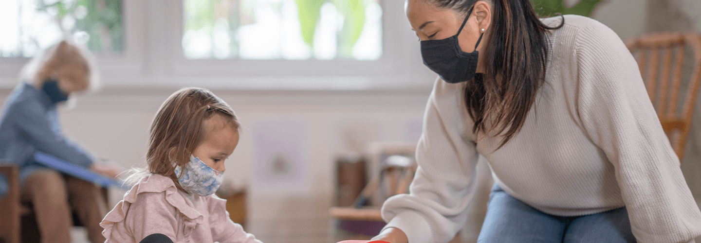 Woman and child wearing masks in child care setting