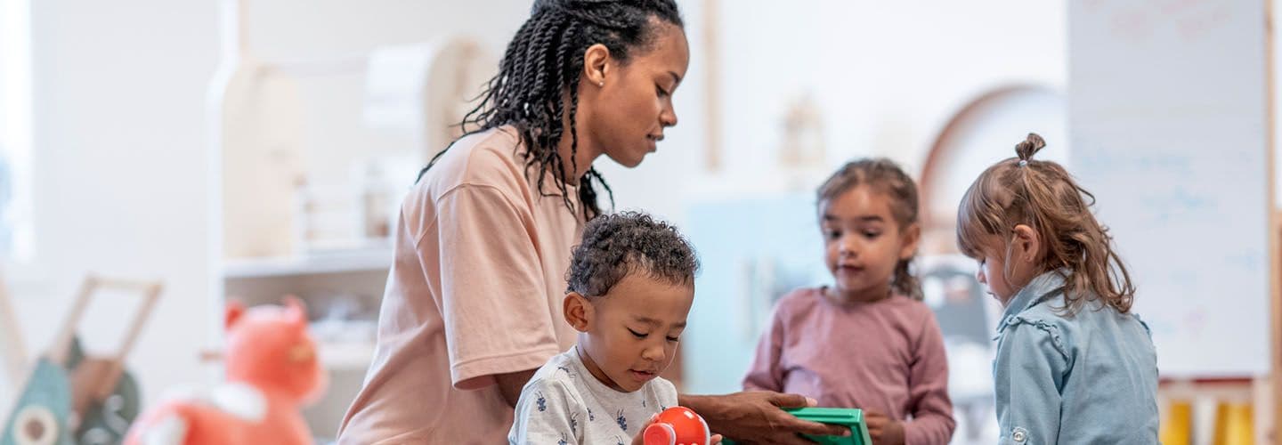 a teacher supervises young children playing together
