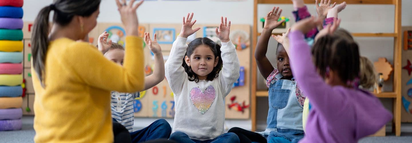 a group of preschoolers sit in a circle