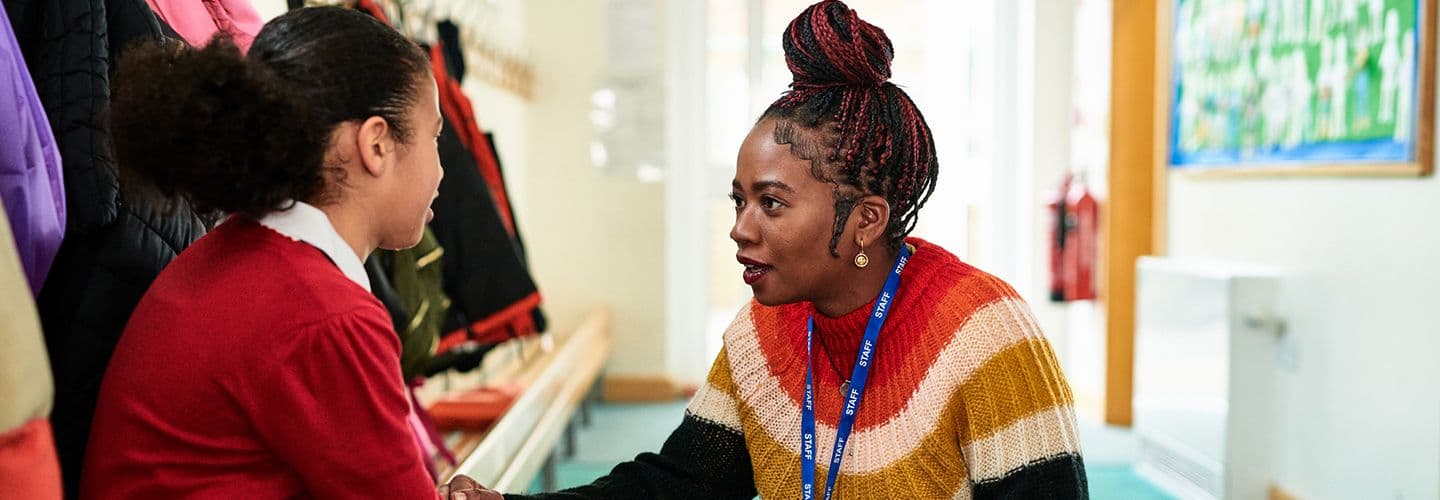 an elementary school teacher talks with a student