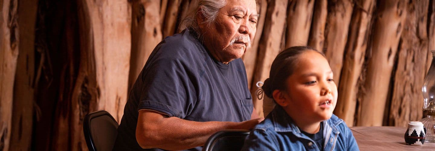 a grandfather braids his grandson's hair