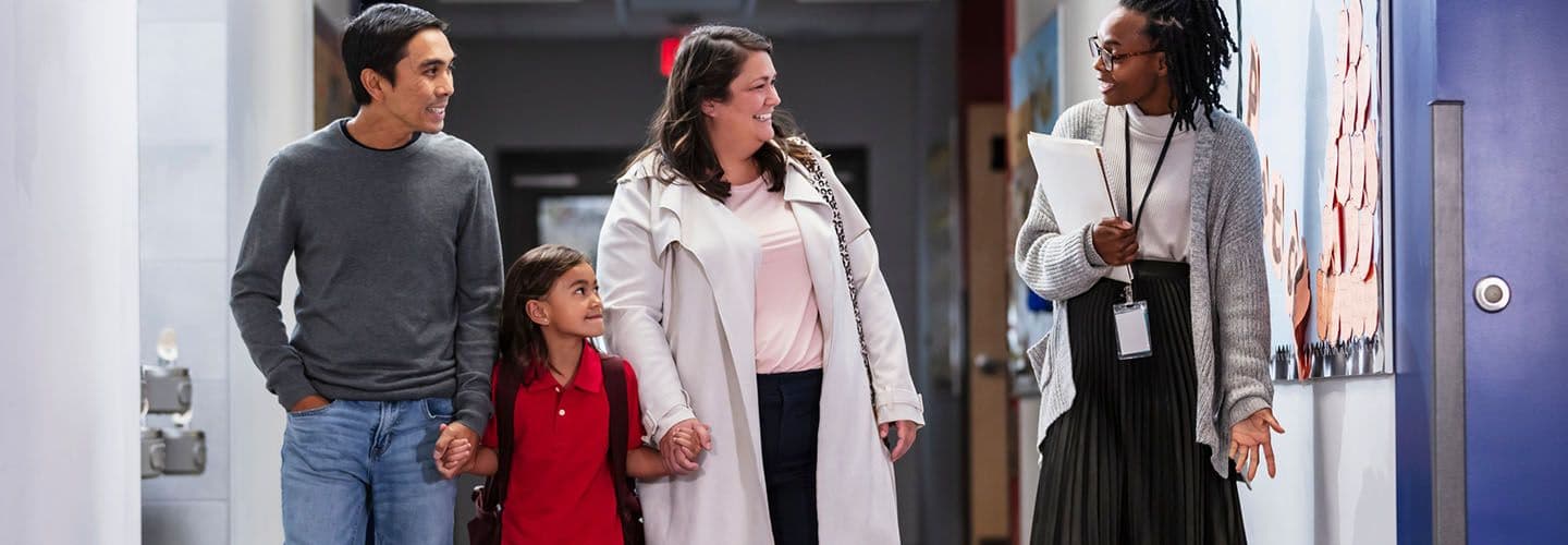 a teacher talks to a family with a young daughter