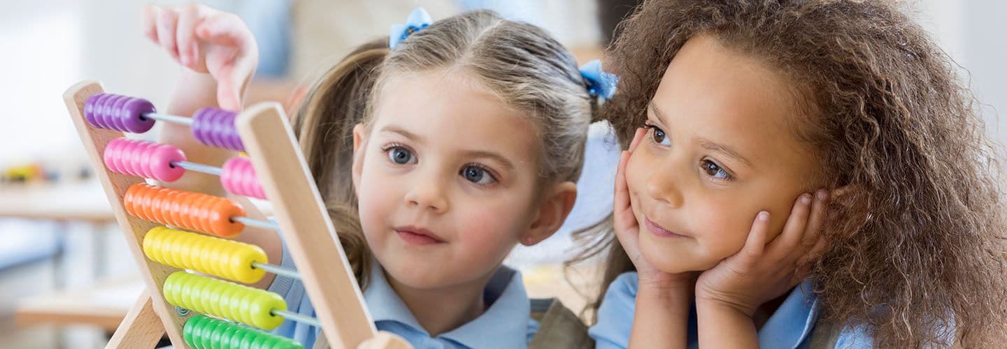 two young girls play with an abacus