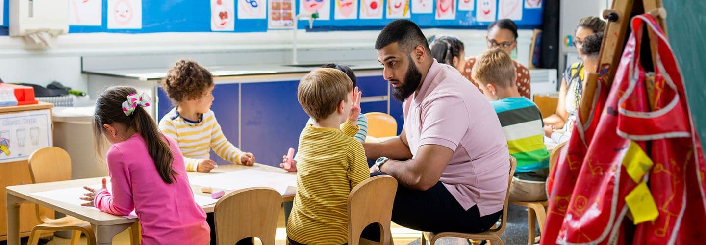 a teacher talks to children at daycare