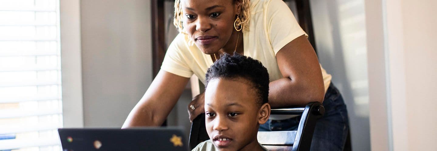 a mother helps her son on the computer